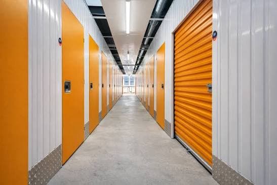 Couloir d'un centre de self-stockage, portes de box orange de part et d'autre