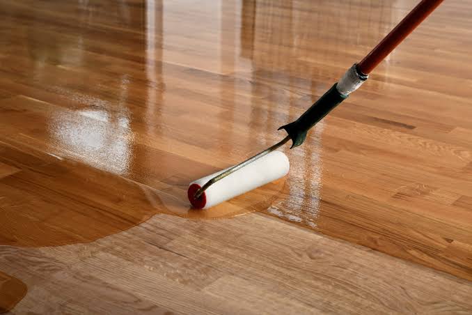 Vitrificateur appliqué au rouleau sur un parquet fraîchement poncé